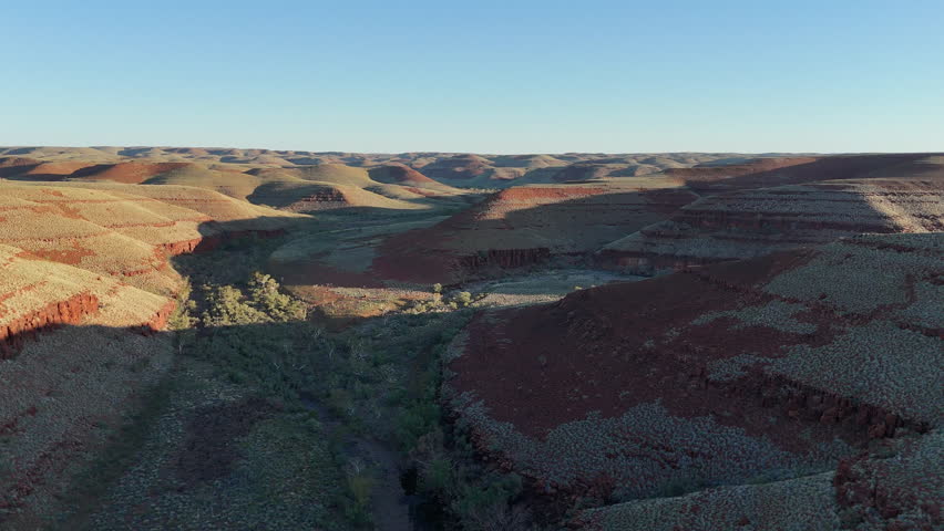 aerial drone shot of a remote bush camp along secluded George river in the beautiful red rolling hills of Millstream Chichester National Park, pilbara shire in West Australia.