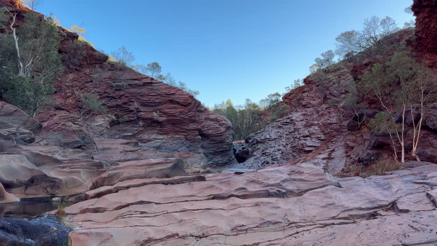 Landscape view of fresh water flowing through the iconic Hamersley Gorge at Karijini National Park Pilbara region in Western Australia.