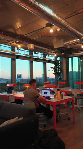 A serene late afternoon in Berlin's Mitte district, capturing the essence of a modern office space with a stunning view of the city skyline