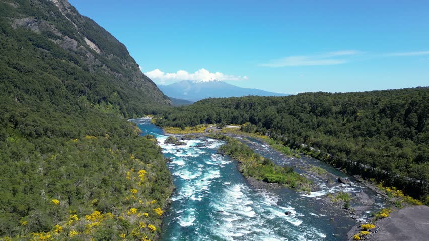 Puerto Varas, Chile: Forward aerial drone footage of Petrohue river with strong rapids near Puerto Varas, Lake District of Chile surrounded by forest with Osorno mountain in the background