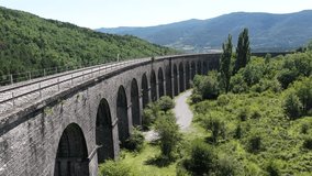 Historic stone railway viaduct arching over verdant valley, connecting mountainous landscape with elegant engineering marvel - Powered by Shutterstock - Get 15% off with code: PIKWIZARD15