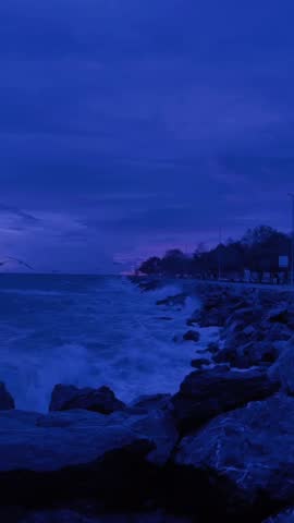 Dramatic Blue Hour Waves Crashing on Rocky Shoreline