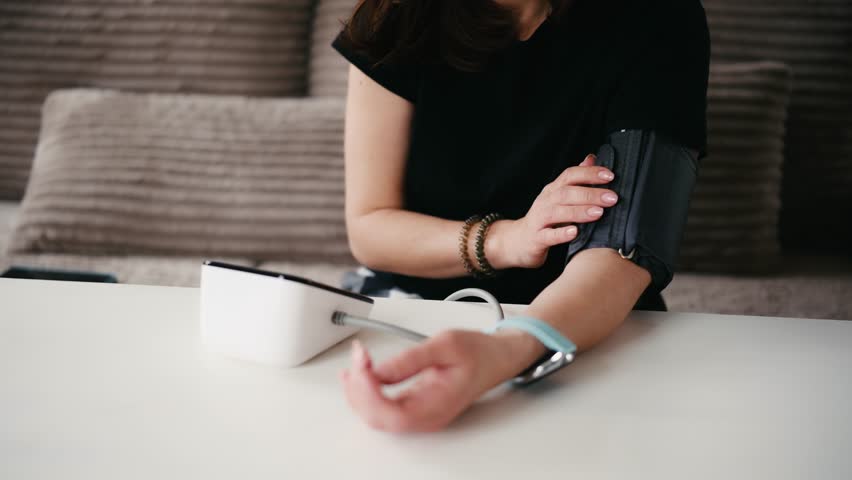 Girl Measuring Blood Pressure With A Digital Monitor, Feeling Unwell