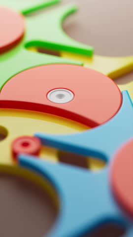 Looped rotation of colorful interlocking plastic gears in blue, yellow, green, and red, creating a seamless, playful, and abstract mechanical pattern with smooth continuous motion.