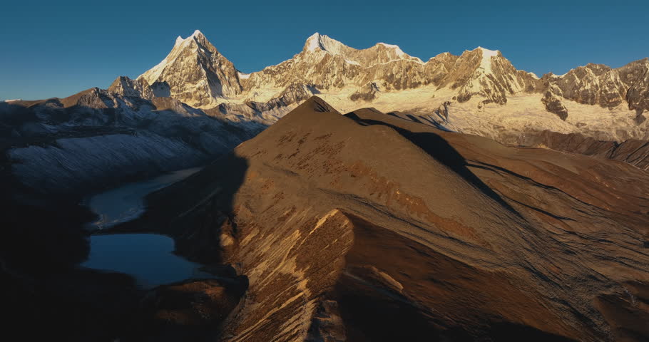 Aerial footage of beautiful snow capped mountain and lake sunrise landscape in Tibet, China