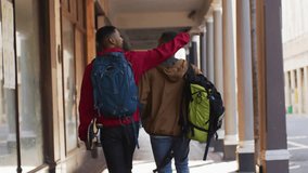 Marketing scene with two friends walking, pointing then draping arm while emoji rising, bonding. Friendship, urban, sidewalk, skateboard, backpack, sunlight, arcade - Powered by Shutterstock - Get 15% off with code: PIKWIZARD15