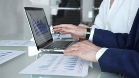 Business professionals examining laptop charts and bar graphs during a modern office meeting, discussing sales performance, market trends, financial analysis and strategy development - Powered by Shutterstock - Get 15% off with code: PIKWIZARD15