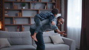 African American family playing airplane pretend at home smiling father piggyback riding little lovely son boy child kid in living room pretending flying happy enjoy parenthood bonding entertainment - Powered by Shutterstock - Get 15% off with code: PIKWIZARD15