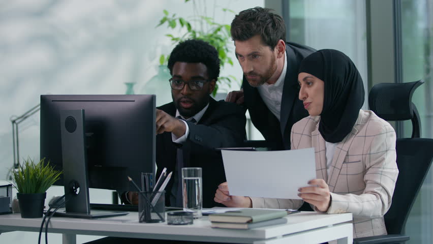 Multicultural business colleagues teamwork in office multiracial three co-workers working together diversity partners talking analyzing data in computer and papers documents meeting brainstorming - Powered by Shutterstock - Get 15% off with code: PIKWIZARD15