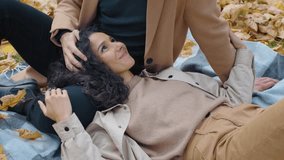 Couple relaxing on picnic in autumn park smiling woman lying on blanket man stroking touching hair of girlfriend family weekend in nature yellow foliage leaves fall season romantic atmosphere love - Powered by Shutterstock - Get 15% off with code: PIKWIZARD15