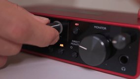 Adjusting external sound card knob, Precise control over audio output through knob rotation, Modifying sound levels using detailed textured dial on external audio interface - Powered by Shutterstock - Get 15% off with code: PIKWIZARD15