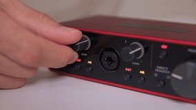 Adjusting external sound card knob, Precise control over audio output through knob rotation, Modifying sound levels using detailed textured dial on external audio interface - Powered by Shutterstock - Get 15% off with code: PIKWIZARD15
