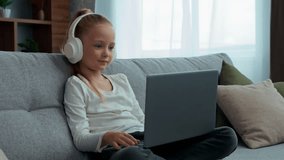 Caucasian smiling pupil child girl communicate video call with laptop hello gesture e-learning daughter in headphones kid schoolgirl with computer talking with online chat virtual conference at home - Powered by Shutterstock - Get 15% off with code: PIKWIZARD15