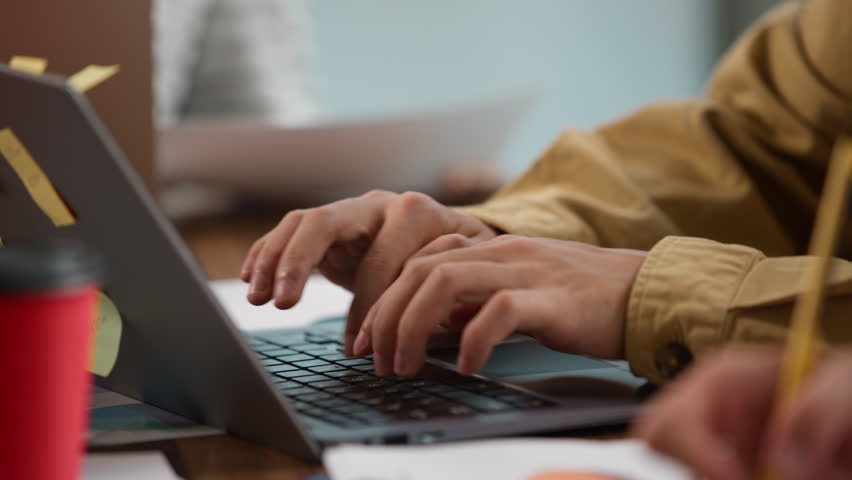 Close up informal business multiracial team working at table indoors Asian man Korean businessman typing laptop online chatting with clients research internet near woman writing notes analyze diagram - Powered by Shutterstock - Get 15% off with code: PIKWIZARD15