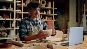 Potter man sculptor talking video call laptop conference online master class teaching sculpture pottery dishware ceramics modeling crockery handmade craft work Caucasian male guy designer craftsman - Powered by Shutterstock - Get 15% off with code: PIKWIZARD15