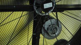 Industrial fan motor and protective grid with yellow striped background, illustrating ventilation - Powered by Shutterstock - Get 15% off with code: PIKWIZARD15