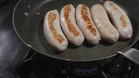 Close-Up of Sausages Browning in a Skillet on a Gas Stove - Powered by Shutterstock - Get 15% off with code: PIKWIZARD15