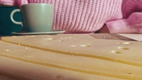 Dynamic macro probe lens video shows a womans hand placing a slice of Swiss cheese on bread for breakfast, with coffee and fresh orange slices on the table - Powered by Shutterstock - Get 15% off with code: PIKWIZARD15