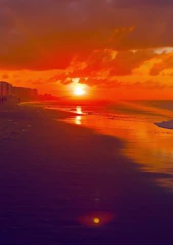 Beautiful golden sunset over the North sea, clouds, city on the horizon, red sky. 