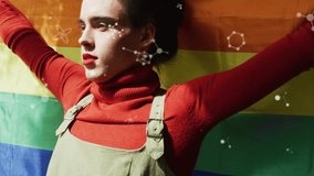 Woman holding arms out molecules rising over pride flag causing closing eyes tilting up for health. Rainbow, portrait, studio, particles, pose, makeup, vibrant - Powered by Shutterstock - Get 15% off with code: PIKWIZARD15
