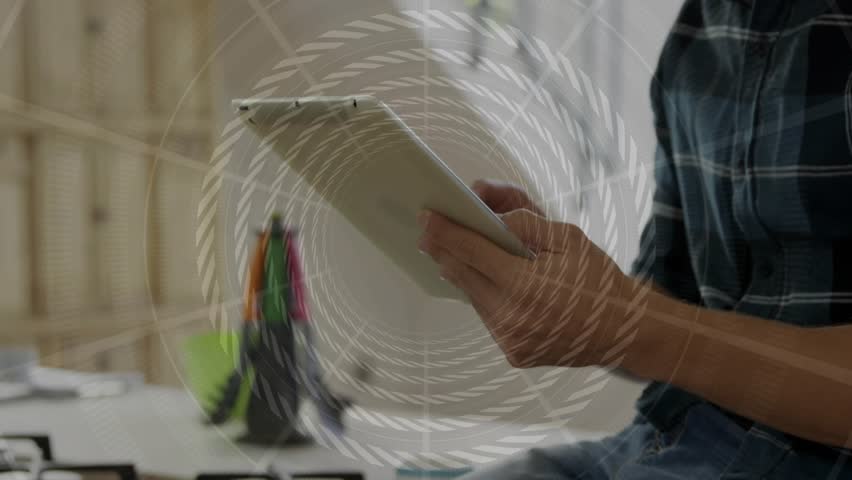 Man tapping tablet top edge and activating spiral overlay while navigating creative app at desk. Touchscreen, hands, focus, studio, pens, notebook, minimalist - Powered by Shutterstock - Get 15% off with code: PIKWIZARD15