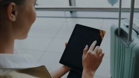 Woman tapping tablet at airport gate, tap causing binary digits overlay near suitcase while waiting. Traveler, device, screen, touchscreen, code, digital, minimalist - Powered by Shutterstock - Get 15% off with code: PIKWIZARD15