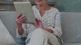 Senior woman tapping tablet on sofa, activating code overlay while finding tech content. Elderly, female, home, digital, engagement, discovery, cozy - Powered by Shutterstock - Get 15% off with code: PIKWIZARD15