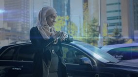 Woman by SUV lifting wrist tapping watch, projecting expanding holo tech network accessing contacts. Smartwatch, wearable, holographic, connectivity, cityscape, daytime, hijab - Powered by Shutterstock - Get 15% off with code: PIKWIZARD15