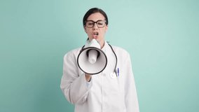 Angry woman doctor in a white coat with a stethoscope shouts into a megaphone. Serious medical professional making an important announcement - Powered by Shutterstock - Get 15% off with code: PIKWIZARD15