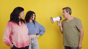 Furious father yelling at his teenage daughter and wife with a megaphone. The man is angry, while the two women look at him with defiance - Powered by Shutterstock - Get 15% off with code: PIKWIZARD15
