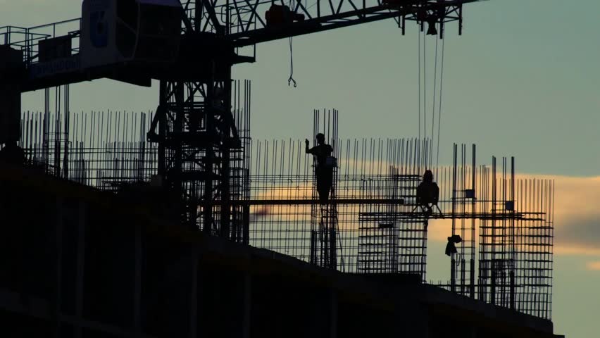 Timelapse of a construction site at sunset, showing cranes, workers, and building progress, capturing the dynamic industrial environment in evening light.