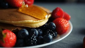 Slow-motion close-up of syrup pouring over a stack of fluffy buttermilk pancakes, highlighting texture, sweetness, and delicious breakfast preparation. - Powered by Shutterstock - Get 15% off with code: PIKWIZARD15