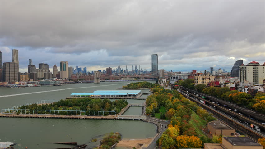 Beautiful Drone aerial view of New York City, New York showing bridges, waterfront roads, tall skyline towers and cloudy soft daylight across the wide urban landscape. Brooklyn, USA