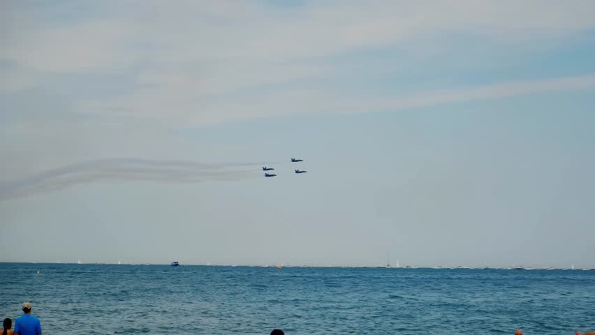 Four military jet fighters fly in formation over a lake in slow motion, capturing powerful motion, precision flight, and dramatic aerial performance.