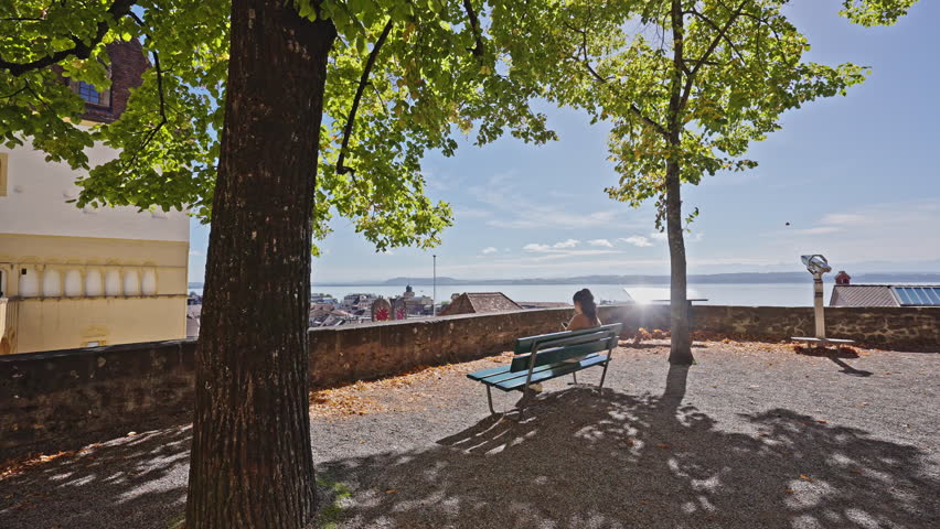Woman Relaxing on Bench at Scenic Overlook Above Neuchâtel, Switzerland.