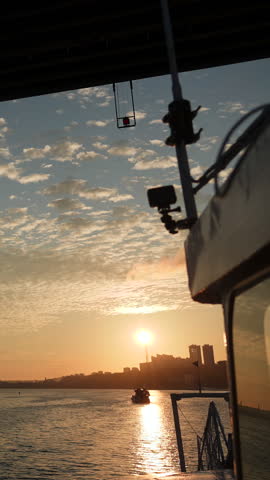 Ship passing under bridge at sunset with clouds. Clip