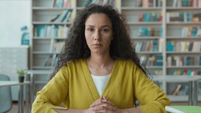 Serious upset Arabian Hispanic woman looking at camera studying in university library calm female student girl learner teacher focused education portrait academic reading knowledge study discipline - Powered by Shutterstock - Get 15% off with code: PIKWIZARD15