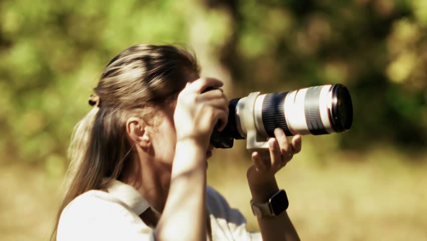 Photographer Capturing Nature With Telephoto Lens, Wildlife  Nature Photography. Professional Photographer Outdoors, Woman Using Digital SLR Camera, Passion For Photography. Adventure And Exploration