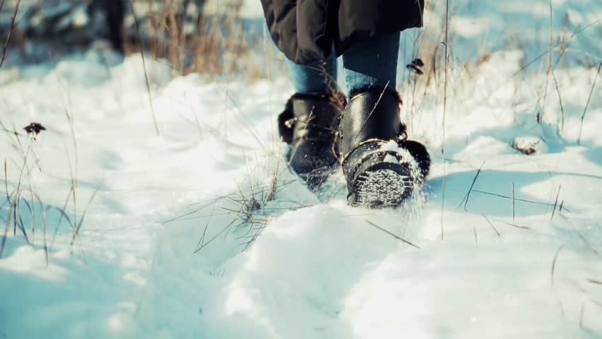 Walking In Snow Wearing Warm Winter Boots. Feet On Snowy Ground. Winter Leisure And Outdoor Activity, Cold Weather Footwear. Snow Covered Warm Clothing. Traveler Walking Seasonal Outdoor Adventure