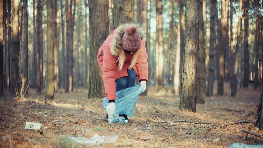 Picking Up Litter In Forest, Environmental Protection And Volunteering. Cleaning Up Wilderness Area, Nature Conservation Activity Volunteer Collecting Trash. Sustainable Lifestyle Commitment 