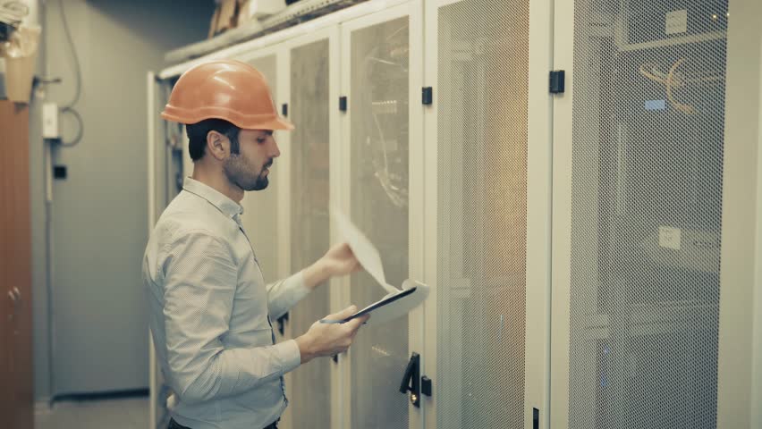 Engineer Checking Servers In Data Center. IT Technician Inspecting Server Racks. Network Maintenance And System Administration Cloud Computing Infrastructure. Cybersecurity Professional Server Room - Powered by Shutterstock - Get 15% off with code: PIKWIZARD15