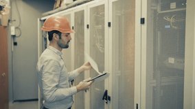Engineer Checking Servers In Data Center. IT Technician Inspecting Server Racks. Network Maintenance And System Administration Cloud Computing Infrastructure. Cybersecurity Professional Server Room - Powered by Shutterstock - Get 15% off with code: PIKWIZARD15