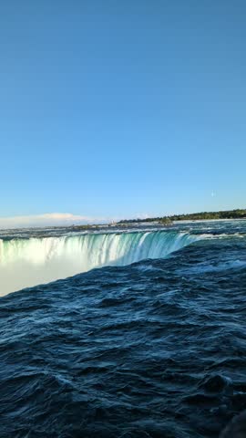 Majestic Horseshoe Falls Edge with Surging Turquoise Water and Rainbow Mist Over Niagara Gorge Ontario Canada - Panoramic View of Whirlpools Foam Clouds and Cliffside Foliage Under Partly Cloudy Sky