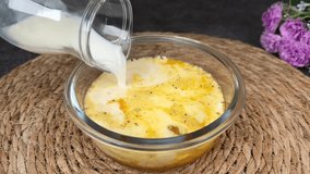 Pouring milk into egg mixture in a glass bowl and whisking with a fork for a breakfast recipe - Powered by Shutterstock - Get 15% off with code: PIKWIZARD15