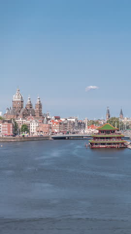 Aerial panorama of a Chinese restaurant in the form of pagoda on the water, set against the backdrop of historical city center buildings and modern architecture timelapse. Amsterdam, Netherlands