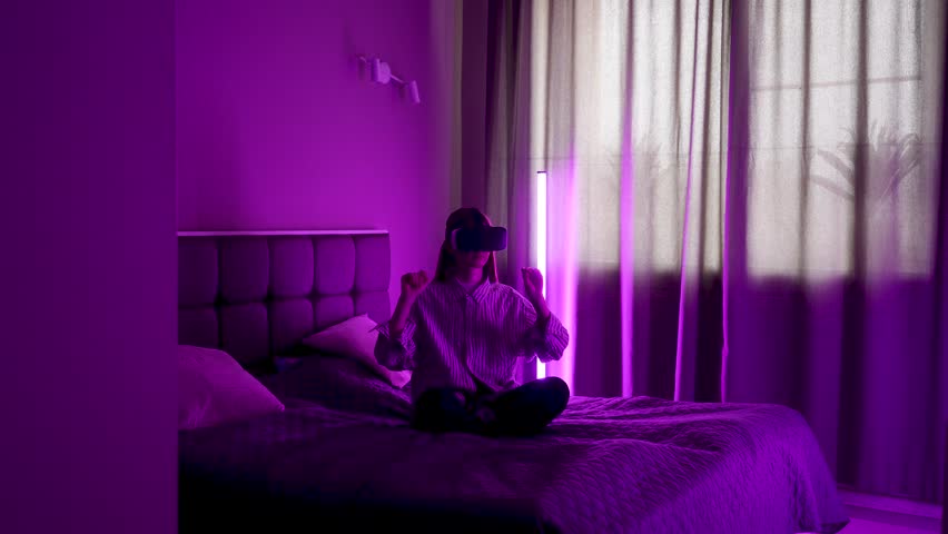 Browsing the internet in virtual reality while sitting on a bed in a purple room