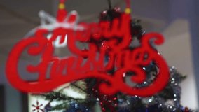 A cinematic rack focus shot shifts blur from the foreground to a festive "Merry Christmas" sign, making the holiday message sharp and clear against bokeh lights. - Powered by Shutterstock - Get 15% off with code: PIKWIZARD15