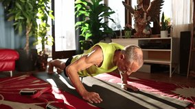 Senior muscular man doing push ups in his room, healthy old age, sports lifestyle, exercising at home for senior adults  - Powered by Shutterstock - Get 15% off with code: PIKWIZARD15
