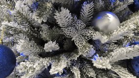 Decorating a winter-themed Christmas tree with blue ribbons and silver ornaments for the holiday season in a cozy indoor setting - Powered by Shutterstock - Get 15% off with code: PIKWIZARD15