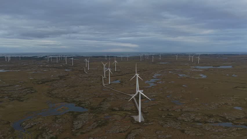 High angle look at windmills on Norway’s windswept Smola island. Aerial drone video